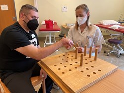 Ergotherapeutin mit Patienten bei der Therapie