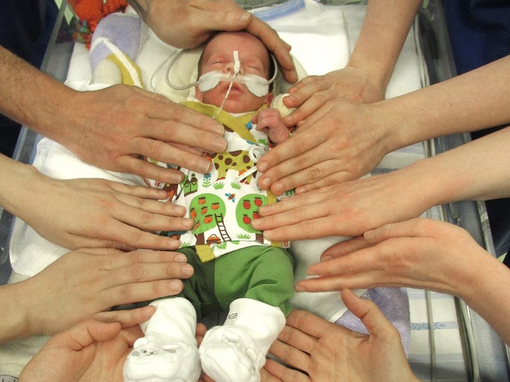 Baby wird von Händen der NIMCU-MitarbeiterInnen berührt