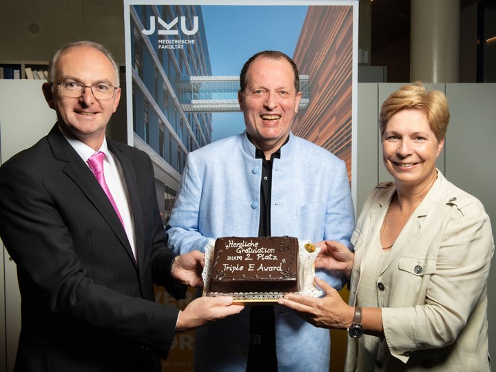 v. l. n. r.: Universitätsprofessor Lamprecht; Professor Fellner, Vizerektorin Drda mit einer Torte anlässlich des Triple E Awards in Silber