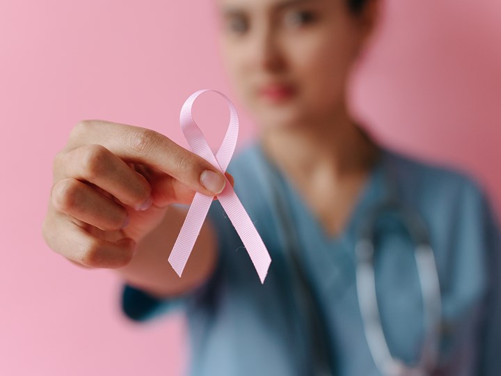 Ärztin mit rosa "Brustkrebs-Schleife" 