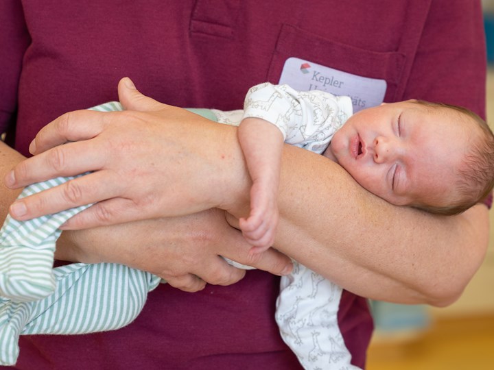 Frühgeborenes in den Armen einer Mitarbeiterin der Klinik für Neonatologie