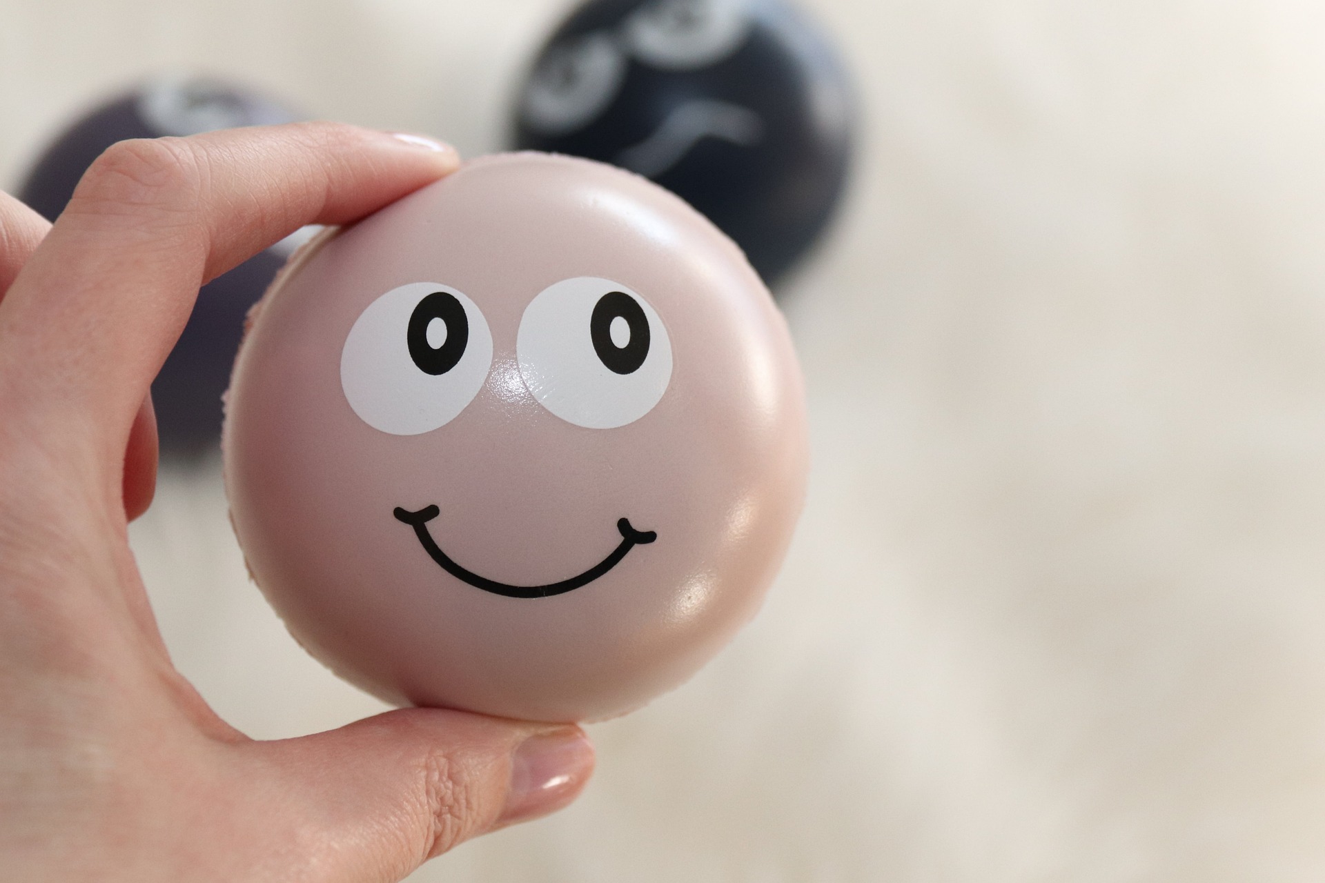 Stressball im Vordergrund und zwei unscharfe Stressbälle im Hintergrund