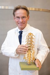 Univ.-Prof. Dr. Andreas Gruber mit einem Wirbelsäulenmodell