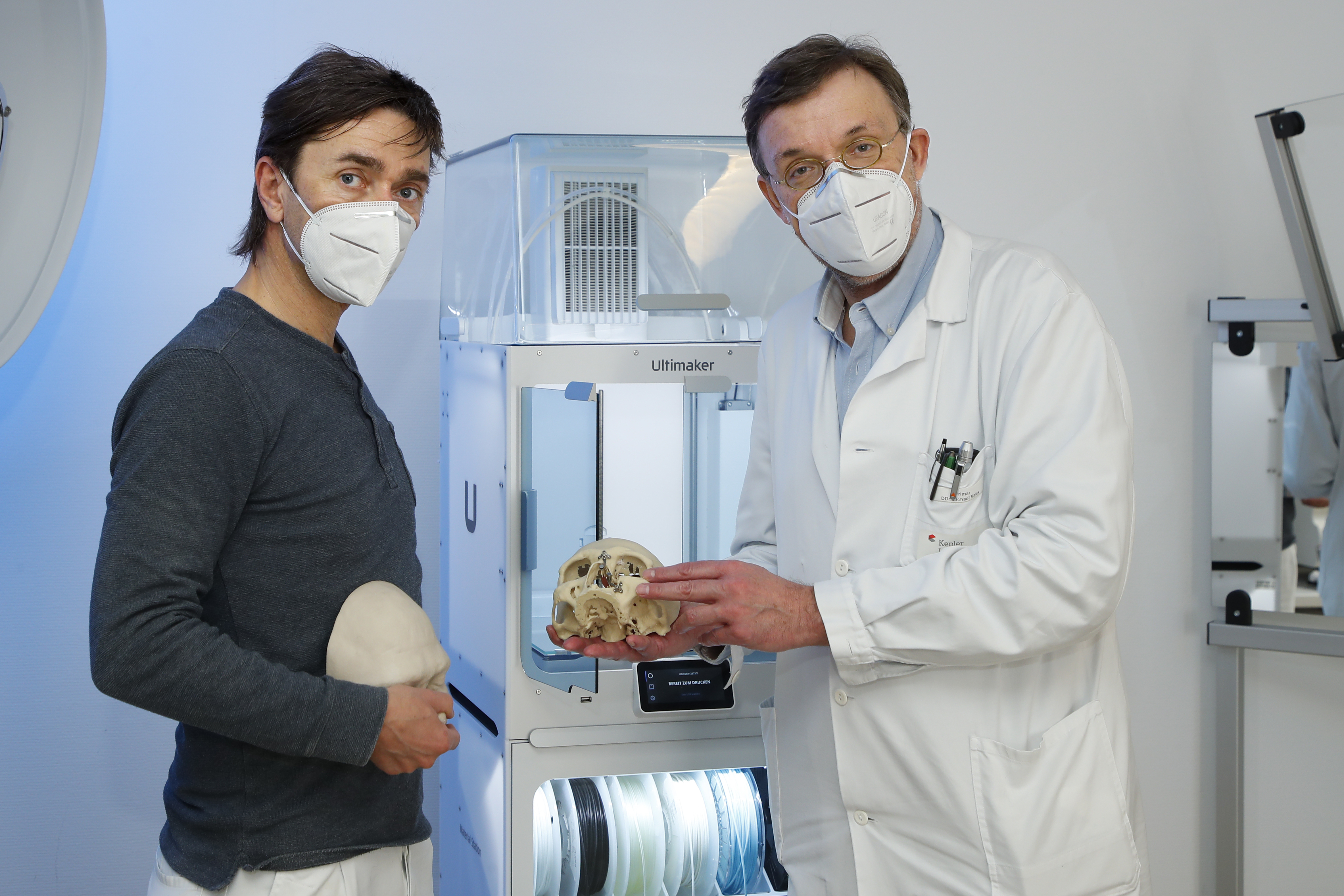 Jürgen Schwarzbauer und Prim. DDr. Michael Malek mit einem Schädelmodell