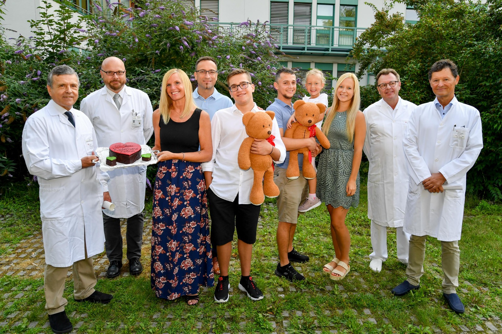 Ärzte Team mit Herzkindern, Eltern und Torte
